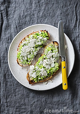 Avocado, goat cheese, grilled ciabatta sandwiches on grey background, top view Stock Photo