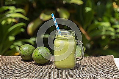 Avocado green shake or smoothie on the table, close up. Breakfast in island Bali, Indonesia Stock Photo
