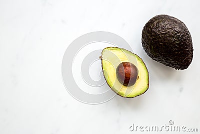 Avocado half on white marble background Stock Photo