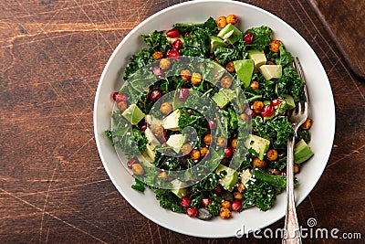 Avocado, kale, roasted chickpeas, almond and pomegranate salad in white bowl Stock Photo