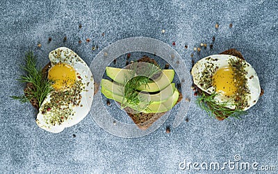 Avocado, sandwiches on whole grain bread with tri-colored tomatoes on rustic baking tray Stock Photo