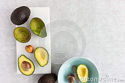 Avocados, Whole, Halved and Scooped Out Stock Photo