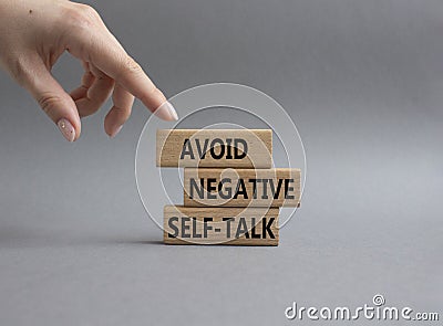 Avoid negative self-talk symbol. Concept words Avoid negative self-talk on wooden blocks. Beautiful grey background. Businessman Stock Photo