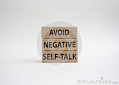 Avoid negative self-talk symbol. Concept words Avoid negative self-talk on wooden blocks. Beautiful white background. Business and Stock Photo