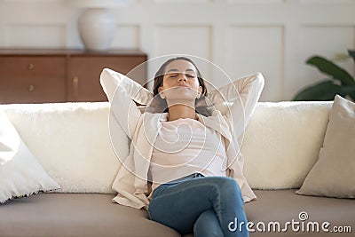 Peaceful young lady resting on comfy sofa enjoying calm moment Stock Photo