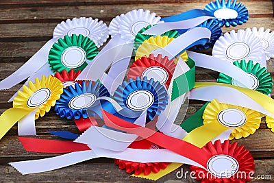Award rosettes for winner in various colors. Colorful ribbons badges for equestrian champions on competition dressage Stock Photo
