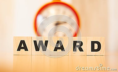 Award word on the background of an orange clock and a wooden business table Stock Photo