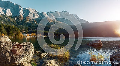 Awesome alpine highlands in sunny day. Nature Landscape. The Eibsee Lake in front of the Zugspitze under sunlight reflected in Stock Photo