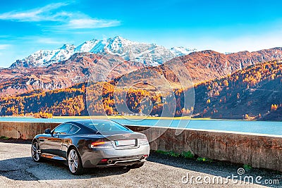 Awesome autumn scene near Maloja village and asphalt road on the shore of Sils lake(Silsersee Editorial Stock Photo