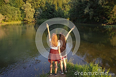 Awesome girl with raised arms are happy as they have reached the lake Stock Photo