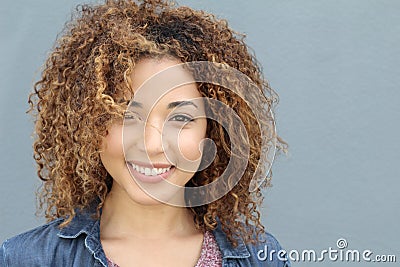 Awesome Hispanic attractive professional female model with curly hair posing in studio smiling isolated on gray background Stock Photo