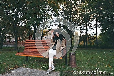 Awesome portrait of young lady, sitting on the wooden bench at the park.Soft colours, awesome place Stock Photo