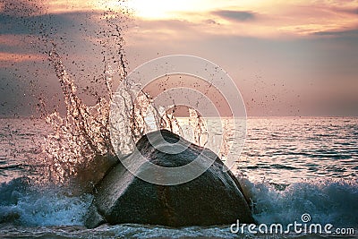 Awesome wave with splashes at sunset Stock Photo