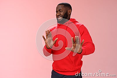 Awkward african american guy step back cringing dislike unwilling go party raise hands no thank stop refusal gesture Stock Photo