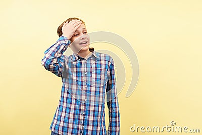 Awkward embarrassed boy covers forehead with hand Stock Photo