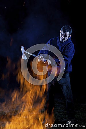 Axe wielding maniac by a fire Stock Photo