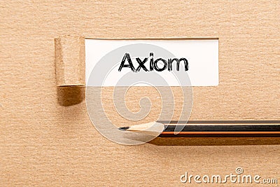 AXIOM, text on white paper appearing behind torn brown paper and pencil Stock Photo