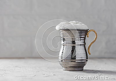 AYRAN. Traditional Turkish yoghurt drink with foam in silver metal cup Stock Photo