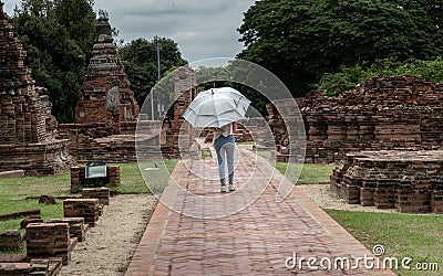 Rear view of Tourist woman holding silver umbrella and walking at Wat Ratchaburana Editorial Stock Photo