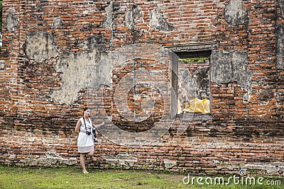 Ayutthaya, Thailand - August 9, 2020: big ancient old red brick wall where has a window frame can see thai ancient statues buddha Editorial Stock Photo