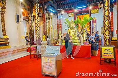 AYUTTHAYA, THAILAND, FEBRUARY, 08, 2018: Unidentified people walking close to a golden budha statue covered with a Editorial Stock Photo