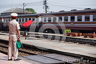 Ayutthaya,Thailand-November 01 2017 :Train staff Make a signal with red flag to people that train arrives Editorial Stock Photo