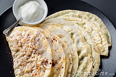 Azerbaijan national cuisine different kutabs with sauce on black plate close up Stock Photo