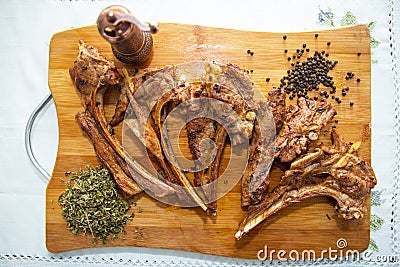 Azeri national antrikot kebab on a wooden board . Dry Satureja . Dried savory spice Satureja hortensis . Copper pepper dish . Stock Photo