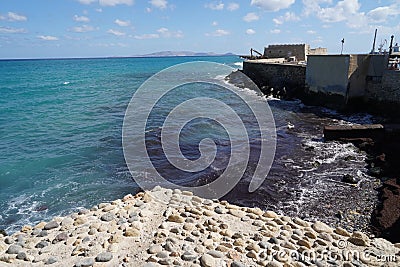 The azure sea in the bay of the island of Crete is bordered by a rocky coast. Stock Photo