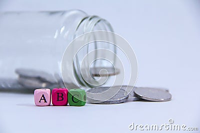 A,B and C in wooden block with coin at the back Stock Photo