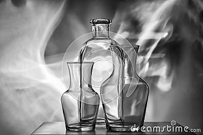 Glass transparent tableware-bottles of different sizes, three pieces on a black and white photo. very beautiful still life. Stock Photo