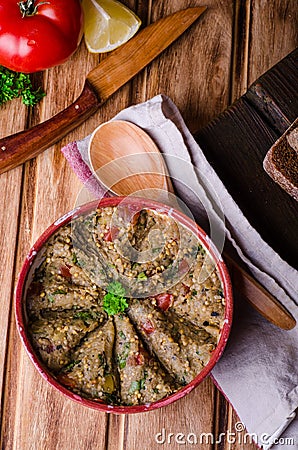 Babaganoush with tomatoes, cucumber and parsley - arabian eggplant dish or salad on wooden background. Selective focus Stock Photo