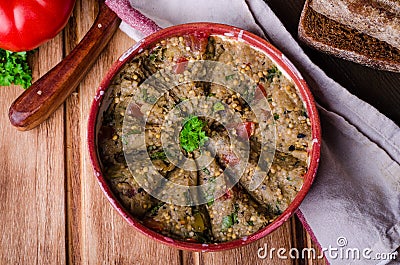 Babaganoush with tomatoes, cucumber and parsley - arabian eggplant dish or salad on wooden background. Selective focus Stock Photo