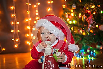 The baby around the Christmas tree with lights Stock Photo
