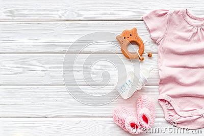 Baby background - pink color. Clothes, booties and accessories for newborn girl on white wooden table top-down frame Stock Photo