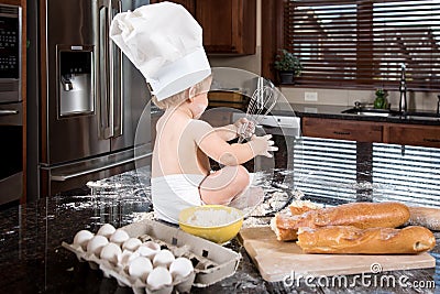 Baby Baker Sitting in Kitchen Stock Photo