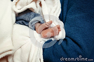 baby baptism. little feet of a boy with holy water at christening ceremony in church in godfather hands Stock Photo