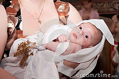 Baby baptized in the arms of his godmother Editorial Stock Photo