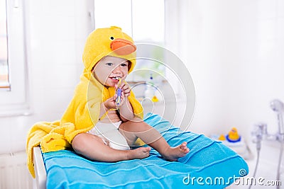 Baby in bath towel with tooth brush Stock Photo
