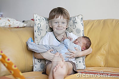 Baby being held tenderly by big brother Stock Photo