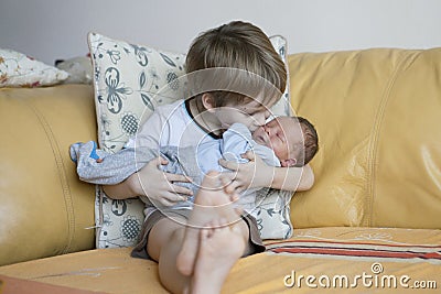 Baby being held tenderly by big brother Stock Photo