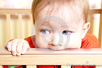 Baby In Bitting On Crib Stock Photo