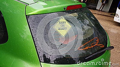 Baby on board yelllow sign on green cara Stock Photo