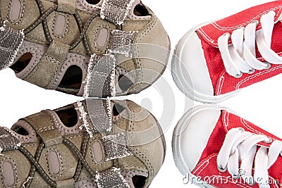 Baby bootees opposite adult sneakers Stock Photo