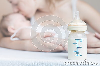 Baby bottle with breast milk and mother with baby Stock Photo