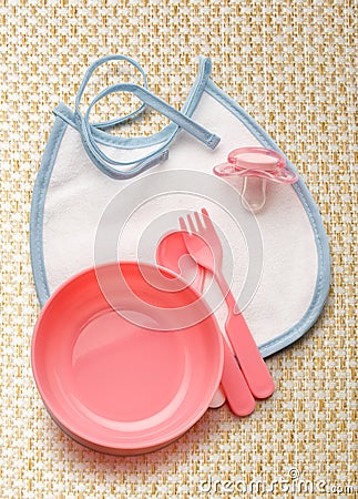 Baby bowl, spoon and fork with dummy Stock Photo