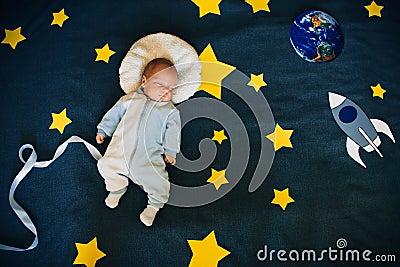 Baby boy is asleep and dreams himself an astronaut in space Stock Photo