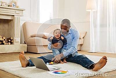 Happy father amusing his crying son Stock Photo