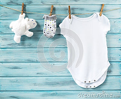 Baby boy clothes and white bear toy on a clothesline Stock Photo