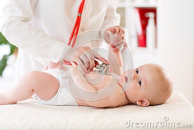 Baby boy in diaper during a medical. Doctor examines kid with stethoscope Stock Photo